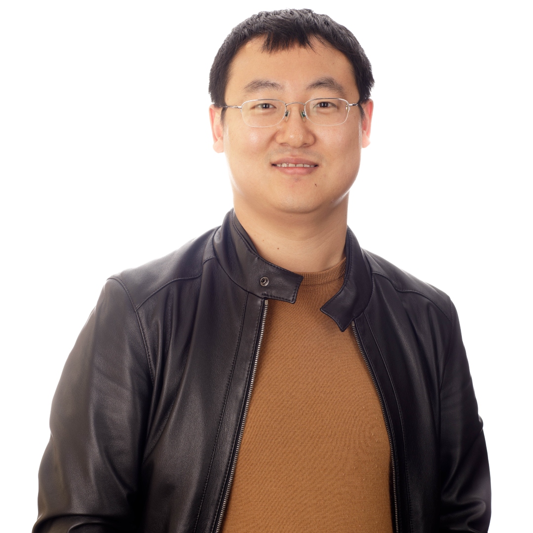 Assistant Professor, Xiaoke Zhang, wearing a leather jacket and yellow sweater in front of a white background