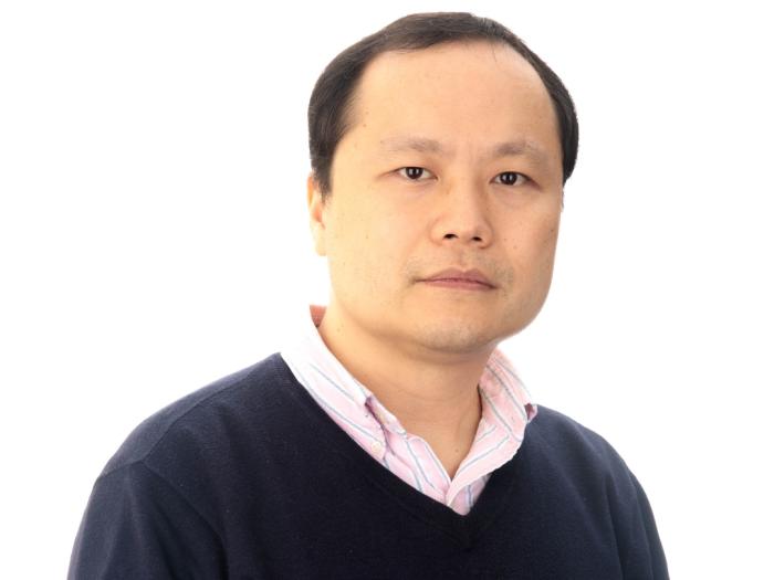 Professor of Statistics, Yinglei Lai, in a blue sweater